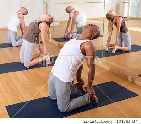 Man making yoga exercises at group class 101283434