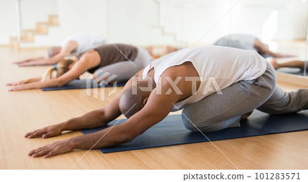 Man making yoga exercises at group class Man making yoga exercises at group class 101283571