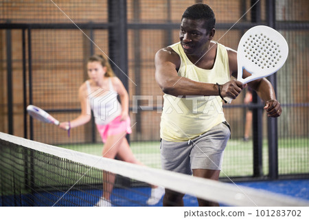 Sporty afro american man playing padel tennis indoor 101283702
