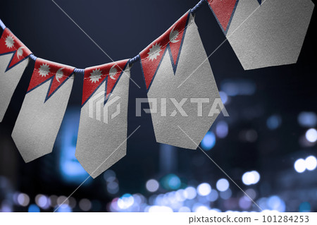 A garland of Nepal national flags on an abstract blurred background 101284253
