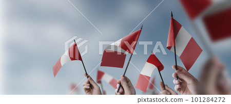 A group of people holding small flags of the Peru in their hands A group of people holding small flags of the Peru in their hands 101284272