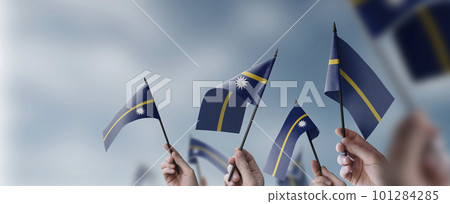A group of people holding small flags of the Nauru in their hands 101284285