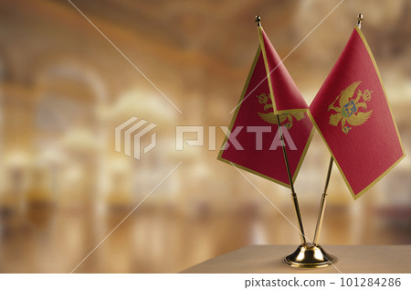 Small flags of the Montenegro on an abstract blurry background 101284286