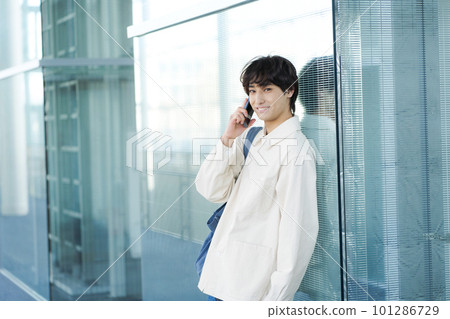 一個年輕人談話在智能手機 一個年輕人談話在智能手機 101286729