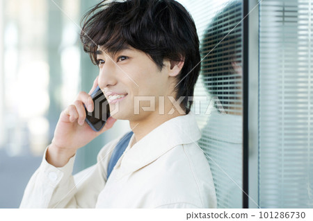 一個年輕人談話在智能手機 一個年輕人談話在智能手機 101286730