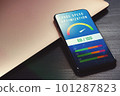 Boost mobile website performance with page speed optimization. High-value accelerometer on phone screen beside laptop on black wooden table for SEO digital marketing visuals 101287823