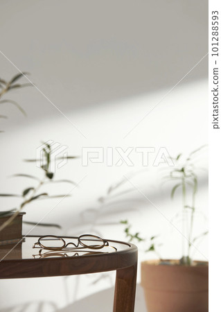 This room has a calm atmosphere with natural light. There are clay pots, glass bottles, coffee and various objects on the table. 101288593