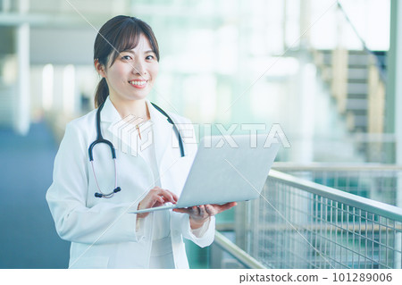 A female doctor in a white coat with a personal computer A female doctor in a white coat with a personal computer 101289006