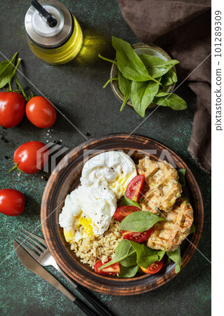Zucchini vegan waffles, poached egg, quinoa and fresh vegetable salad on a stone tabletop. Keto diet. Delicious breakfast or brunch. View from above. Zucchini vegan waffles, poached egg, quinoa and fresh vegetable salad on a stone tabletop. Keto diet. Delicious breakfast or brunch. View from above. 101289309