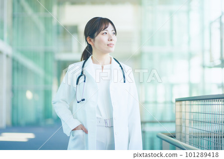 A female doctor wearing a white coat walking in the hospital A female doctor wearing a white coat walking in the hospital 101289418