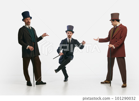 Portrait with three men wearing old-fashioned clothes and posing over white background. Gentlemen 101290032
