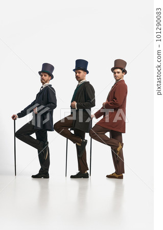 Portrait with three men wearing old-fashioned clothes and standing in a row over white background. Side view. Gentlemen Portrait with three men wearing old-fashioned clothes and standing in a row over white background. Side view. Gentlemen 101290083