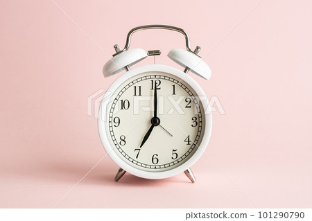 A white alarm clock on a pink background Image photo of feminine time A white alarm clock on a pink background Image photo of feminine time 101290790