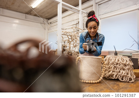 Dark-haired woman making photos of handmade bags 101291387