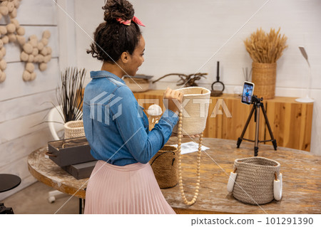 Young woman demonstrating knitted bags on camera 101291390