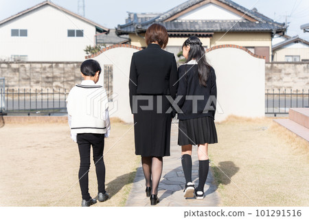 A family of three in mourning clothes heading to a funeral A family of three in mourning clothes heading to a funeral 101291516