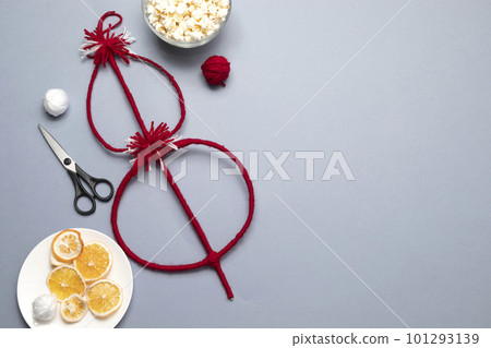 Top view Survakane, Survachka, Surva On Gray Background. Bulgarian Traditional Cornel Christmas Stick With Dried Fruits, Red, White Threads, Popcorn, Dried Orange.Copy space For text,Horizontal Plane 101293139