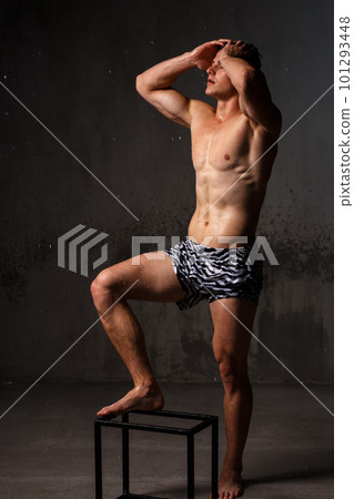 Athlete bodybuilder trains in the studio in the rain. 101293448