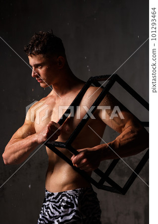 Athlete bodybuilder trains in the studio in the rain. Athlete bodybuilder trains in the studio in the rain. 101293464