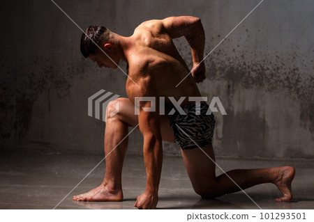 Athlete bodybuilder trains in the studio in the rain. Athlete bodybuilder trains in the studio in the rain. 101293501