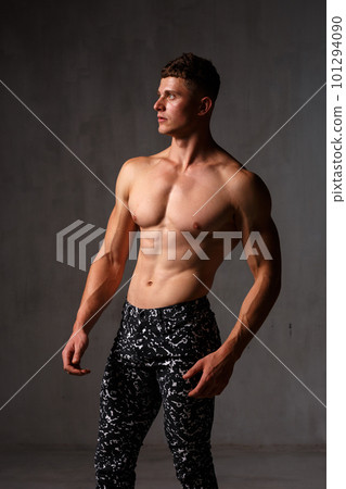 A guy in a great sports uniform in the studio on a gray background. 101294090