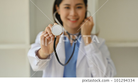Selective focus on hand of doctor in white uniform holding stethoscope. Healthcare and medical concept 101294334