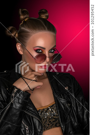 Portrait of a young sassy girl with blond hair in the studio on a pink background. Portrait of a young sassy girl with blond hair in the studio on a pink background. 101295452