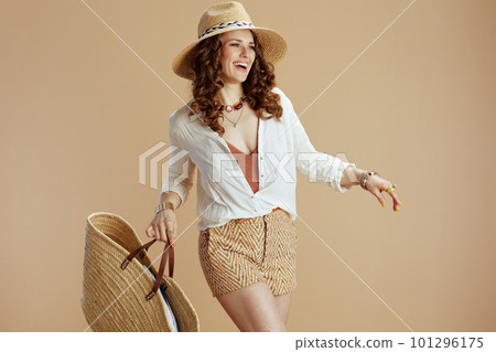 smiling elegant woman in blouse and shorts isolated on beige 101296175