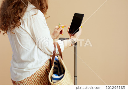 Trendy woman showing smartphone blank screen isolated on beige 101296185