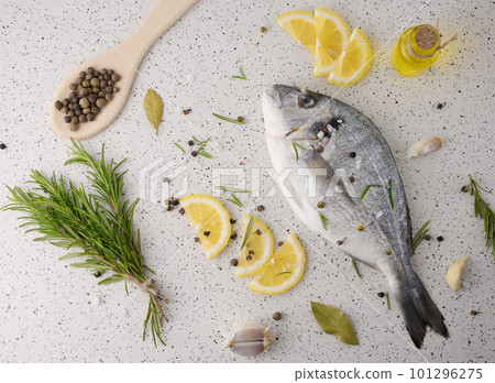 Raw whole dorado fish on white board and spices for cooking, top view on white table 101296275