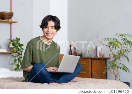 在臥室裡使用電腦的年輕人 101296790