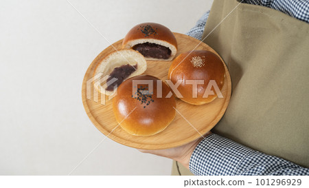 A person in an apron holding an anpan A person in an apron holding an anpan 101296929