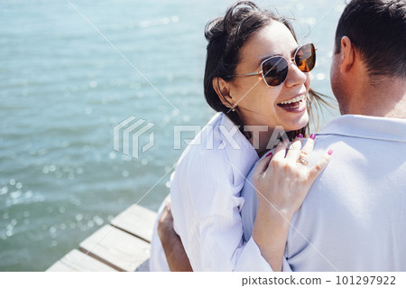 Young couple in love in light casual clothes is sitting on wooden bridge 101297922