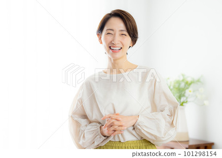 A middle-aged woman looking at the camera and smiling A middle-aged woman looking at the camera and smiling 101298154