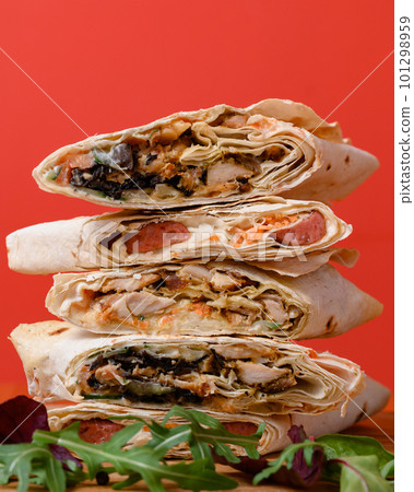 Three types of cut shawarma placed on top of each other, red background and fast food. Three types of cut shawarma placed on top of each other, red background and fast food. 101298959