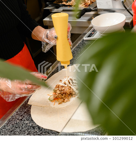 Shawarma preparation in a fast food restaurant, vegetable and meat shawarma. Shawarma preparation in a fast food restaurant, vegetable and meat shawarma. 101299012