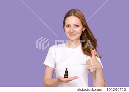 Skin care concept. Beauty portrait young woman holding pipette with cosmetic 101299710