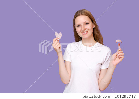Young lady massaging her face by Gua Sha Quartz Stone Scraper for skin care 101299718