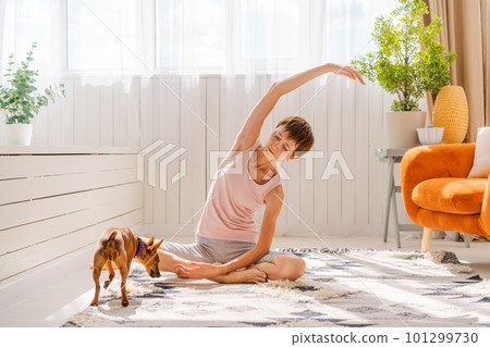 Concept healthy lifestyle. Yoga and fitness. Cute woman with small dog Concept healthy lifestyle. Yoga and fitness. Cute woman with small dog 101299730