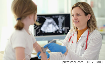 Doctor traumatologist making ultrasound examination of elbows of little girl in clinic 101299809