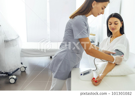 Blood pressure monitor and female hand with red manicure Blood pressure monitor and female hand with red manicure 101301082