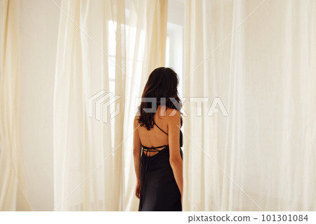 Attractive young woman in classic evening black dress. Attractive young woman in classic evening black dress. 101301084