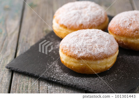 Ruddy delicious donuts berliners with filling sprinkled on a stone board 101301443