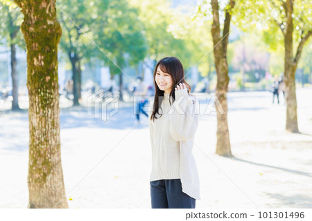 走在綠樹成蔭的街道上的年輕女人 101301496