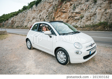 Single woman into convertible top automobile on summer day - travel trip and summer holidays Single woman into convertible top automobile on summer day - travel trip and summer holidays 101303182
