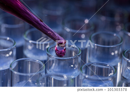 Pipette dropping fluid into test tube 101303378