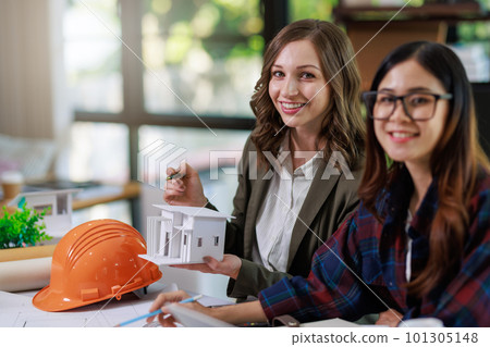 Construction concept of Engineer and Architect working with Construction model and blueprint before buit at site, Engineer and Architect discussing construction plan with computer laptop calculator 101305148