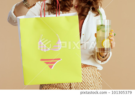 Stylish woman in blouse and shorts against beige Stylish woman in blouse and shorts against beige 101305379