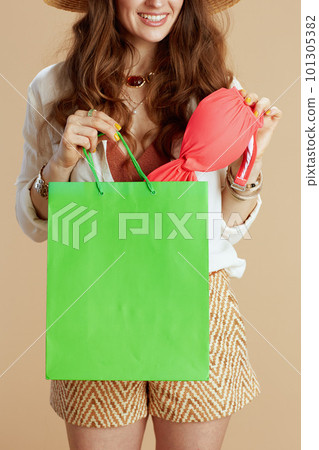 smiling woman in blouse and shorts against beige smiling woman in blouse and shorts against beige 101305382
