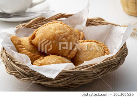 curry puff on wicker basket,fried curry dumpling (with meat or vegetable snuffing) curry puff on wicker basket,fried curry dumpling (with meat or vegetable snuffing) 101305526